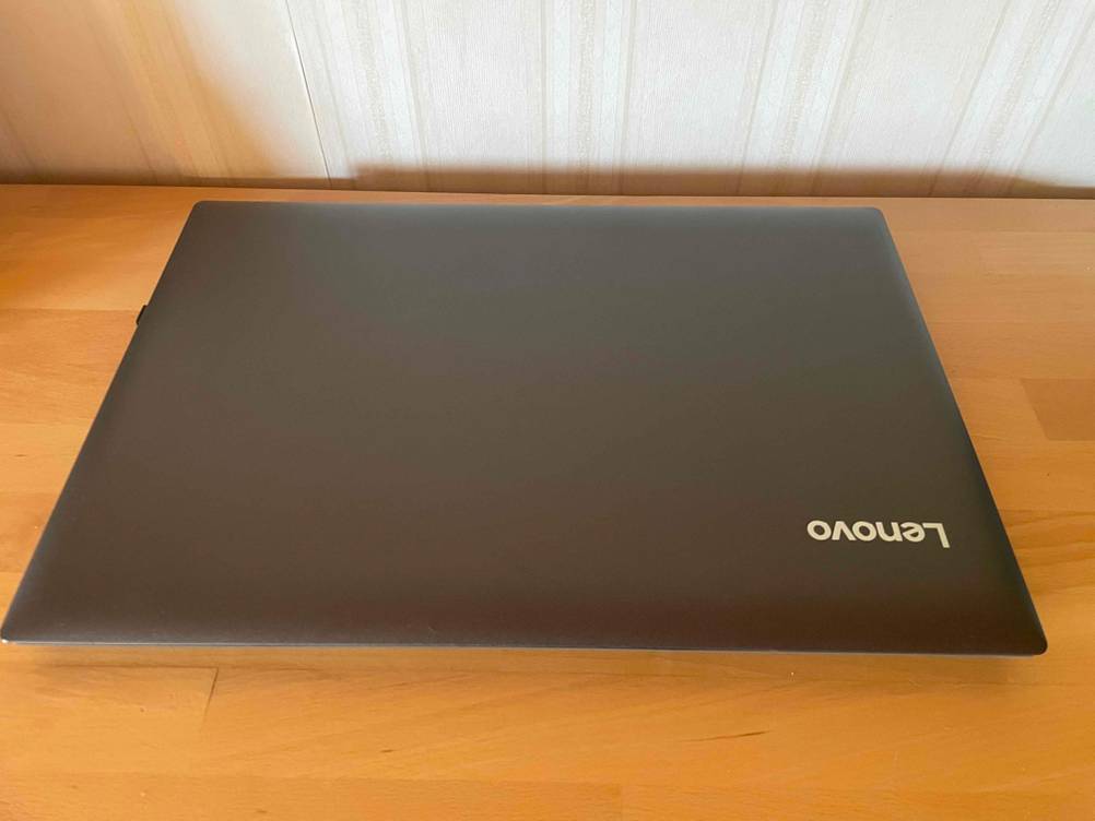 Laptop mit DVD-Laufwerk getestet: Ein geschlossenes Gerät auf einer Holzoberfläche vor einer hellen Wand.