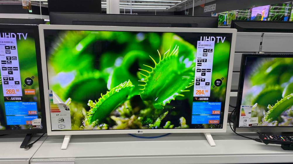 Frontansicht eines 32-Zoll-Fernsehers, der neben anderen Modellen in einem Geschäft steht.
