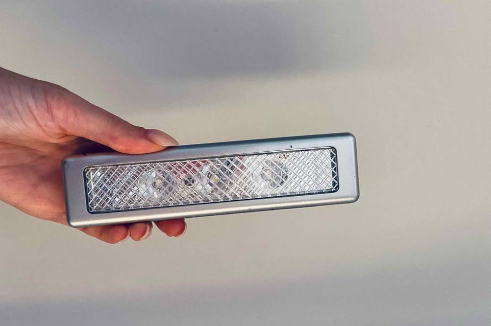 Im Test: Eine Hand hält eine LED-Lightbar vor eine helle Wand.