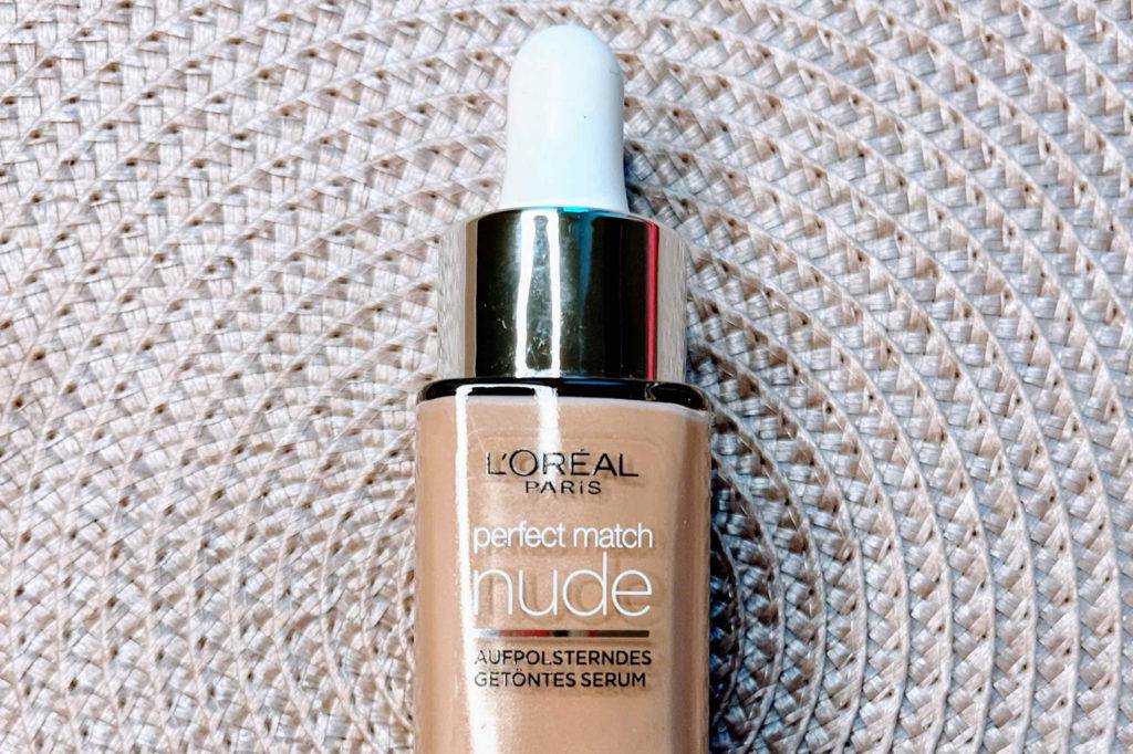 Make-up im Test: Eine Flasche Make-up auf einer hellen Platzdecke liegend
