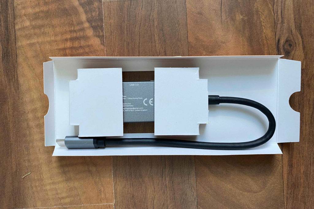 USB-C-Hub im Test: Gerät in einer Kartonverpackung auf einer Holzoberfläche