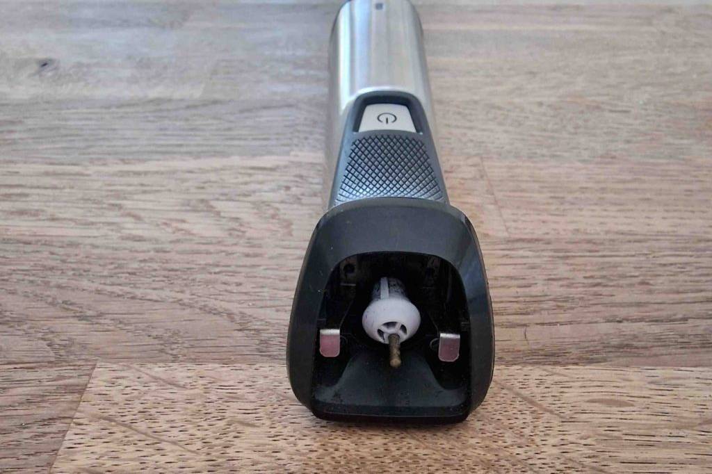 Ein getesteter Philips-Rasierer liegt ohne Schneidekopft auf einer Holzfläche