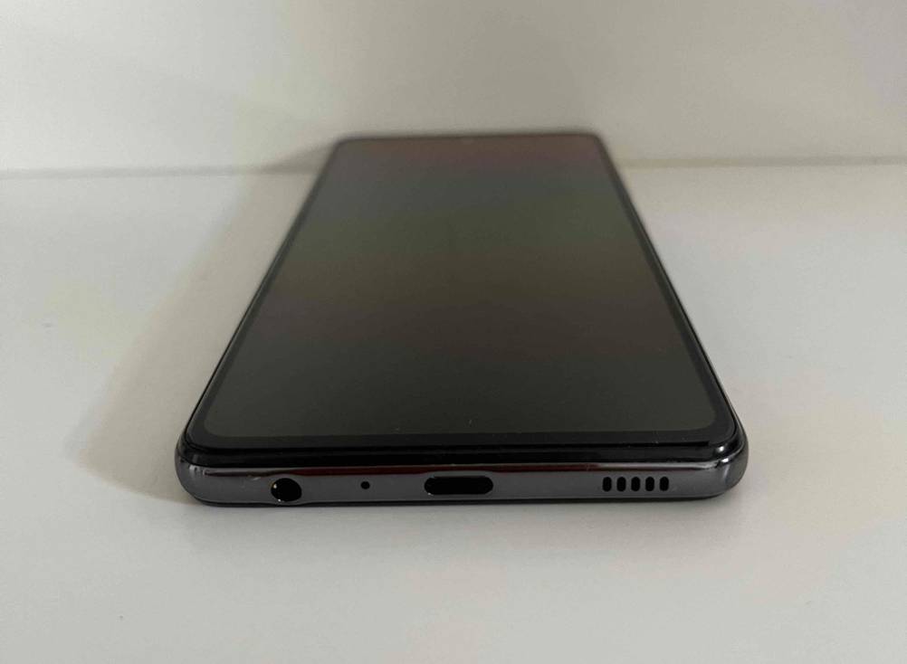 Günstiges-Smartphone-Test: ein Smartphone liegend auf einer weißen Fläche mit Blick auf die Anschlüsse.