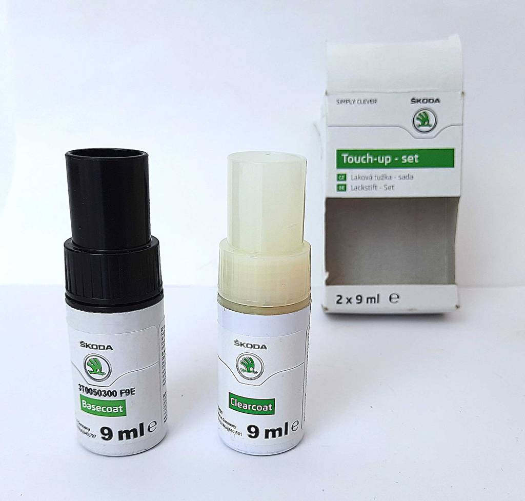 Test von Lackstiften für Autos: Zwei 9-ml-Kunststoffflaschen mit Basis- und Klarlack stehen vor dem Verpackungsset.