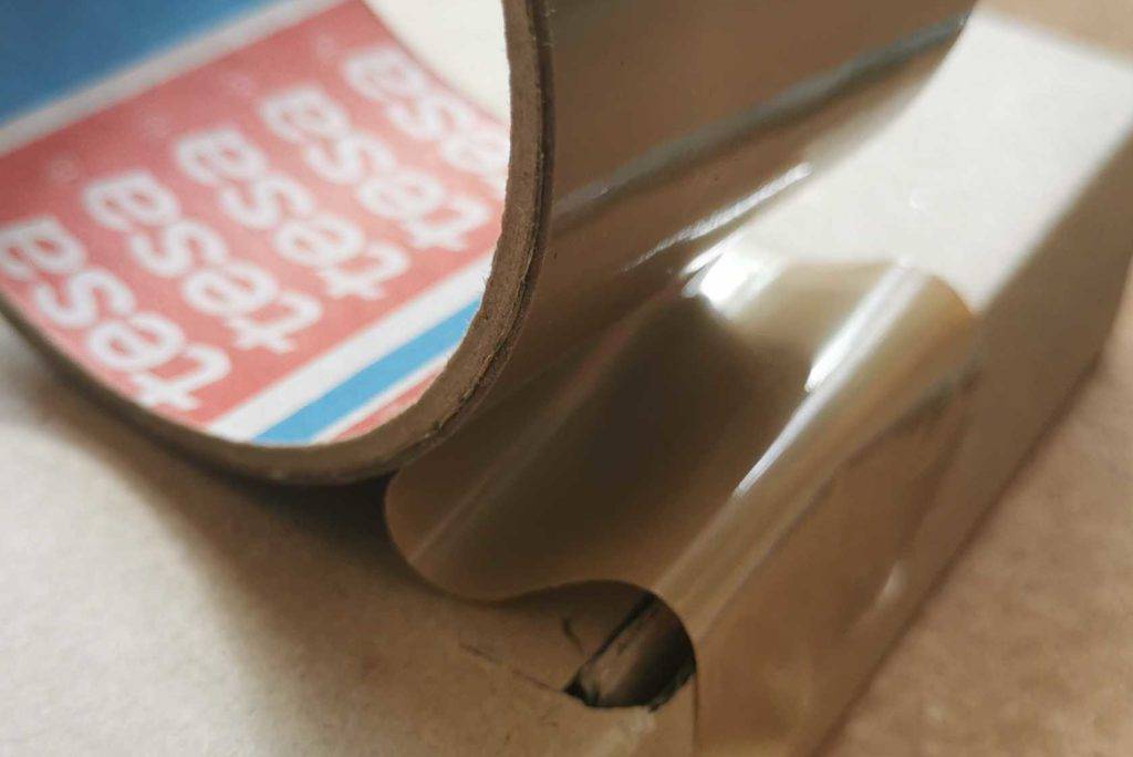 Paketband wird auf Karton geklebt.