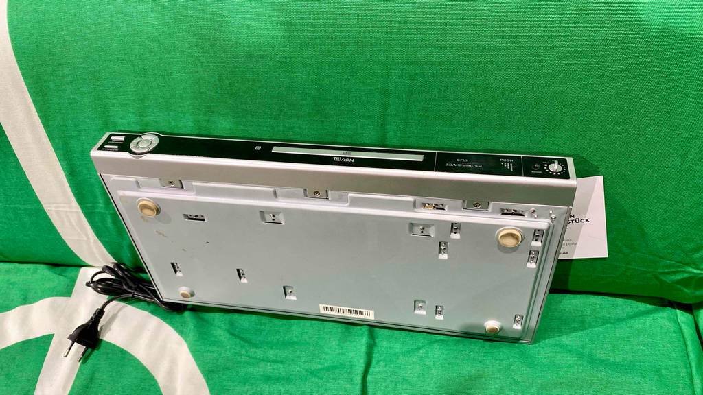 DVD-Player-Test: ein DVD-Player ist auf eine grüne Couch gestellt mit Blick auf die Unterseite.