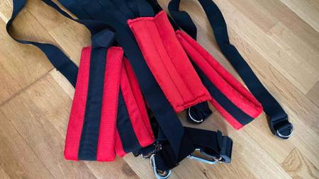 Liebesschaukel im Test: Liebesschaukel mit roten Polsterungen am Boden liegend.