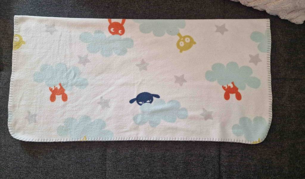 Im Test: Eine gefaltete Babydecke liegt auf einem dunklen Untergrund.