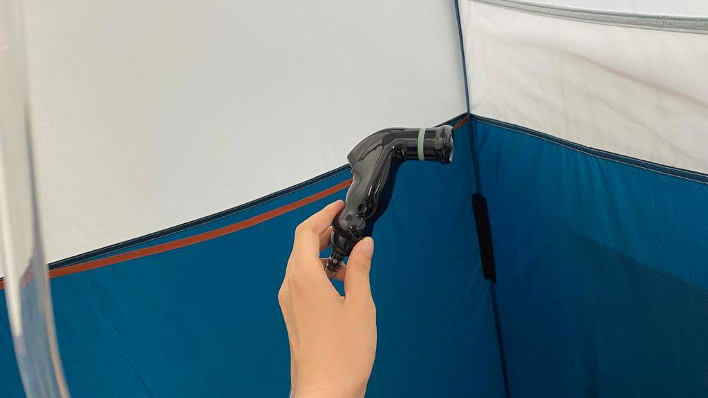 Duschzelt mit Duschkopf in der Hand gehalten