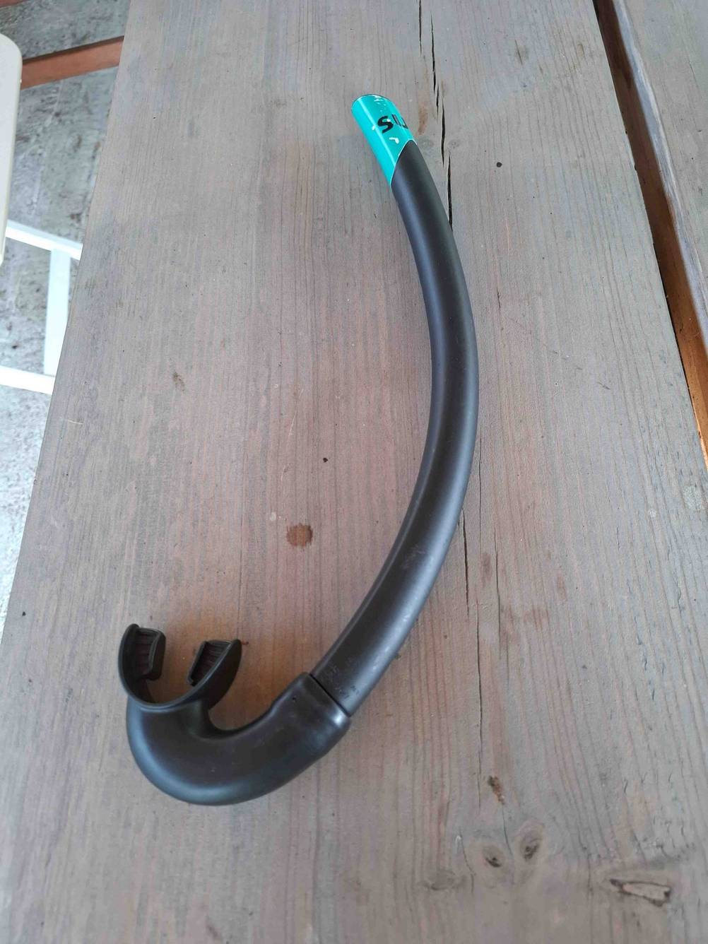 Der getestete Schwimmschnorchel, der auf einem Untergrund aus Holz liegt.