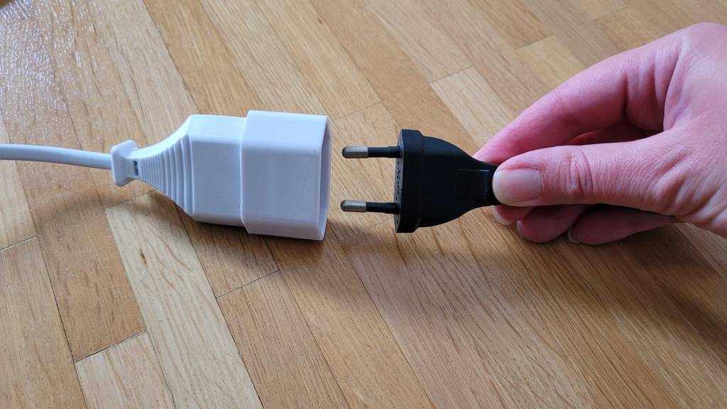 Verlängerungskabel getestet: ein Netzstecker wird in den Anschluss eines Verlängerungskabel gesteckt.
