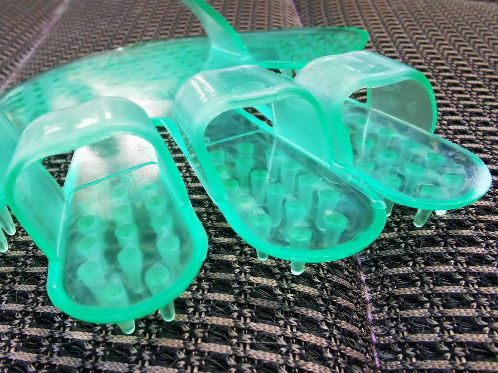 Im Test: Der Fellpflege-Handschuh mit Noppen liegt aus der Nähe betrachtet auf einem grauen Stoff.