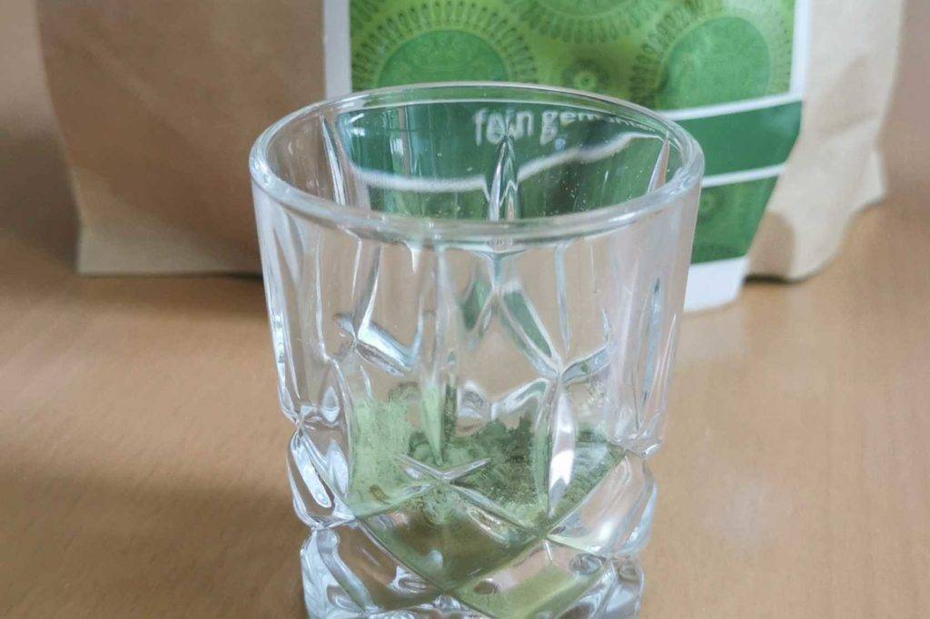 Gerstengras getestet: Ein Glas steht vor einer Packung.