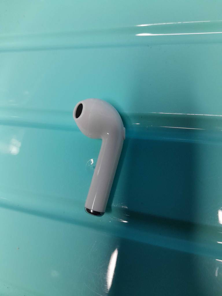 In-ear-noise-cancelling-Test: ein weißer In-ear-Kpfhörer auf einem blauen Untergrund liegend.