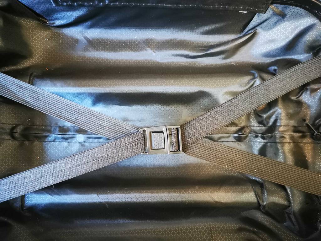 Der getestete Handgepäck-Koffer liegt geöffnet mit Fokus auf den Innengurten auf dem Boden.
