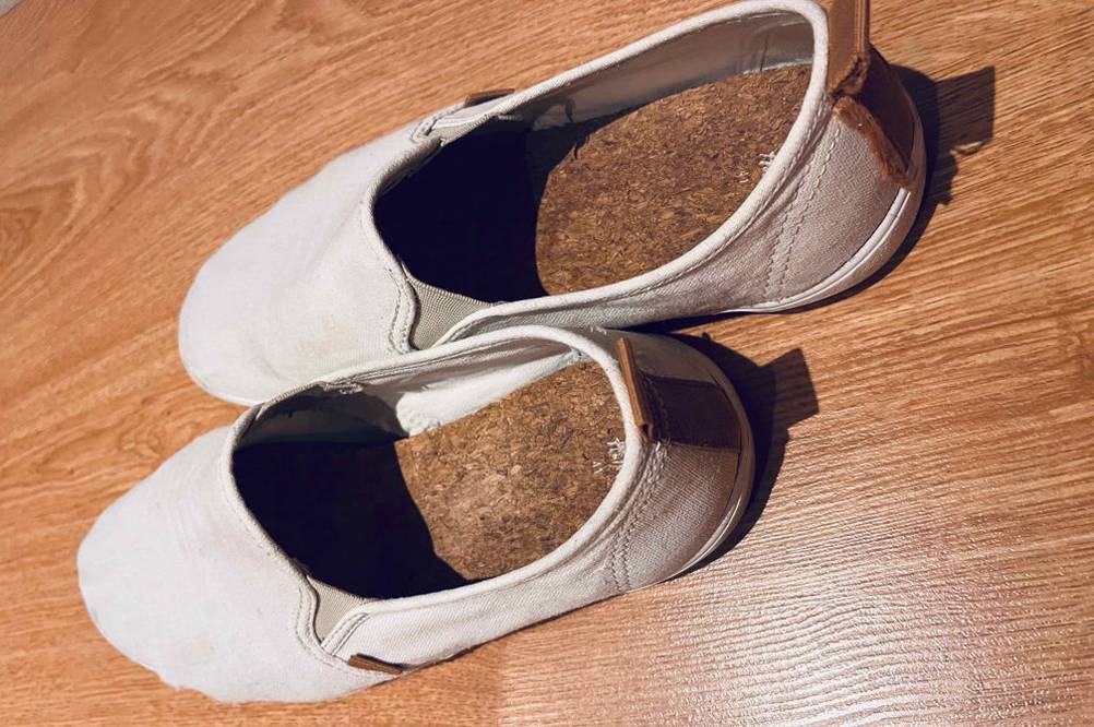 Auf einem Holzboden stehen ein Paar Espadrilles für Herren nebeneinander.