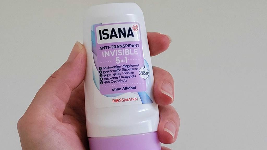 Antitranspirant getestet: Antitranspirant-Roller der Marke Isana wird in der Hand vor einem weißen Hintergrund gehalten.