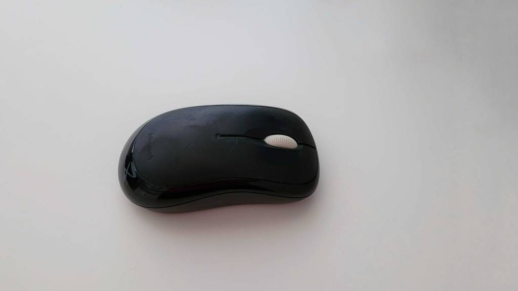 Kabellose-Maus-Test: Schwarze, kabellose Maus auf weißer Oberfläche.