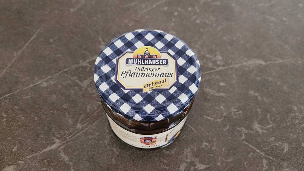 Pflaumenmus im Test: Ein Glas Mus von oben auf dunkler Fläche