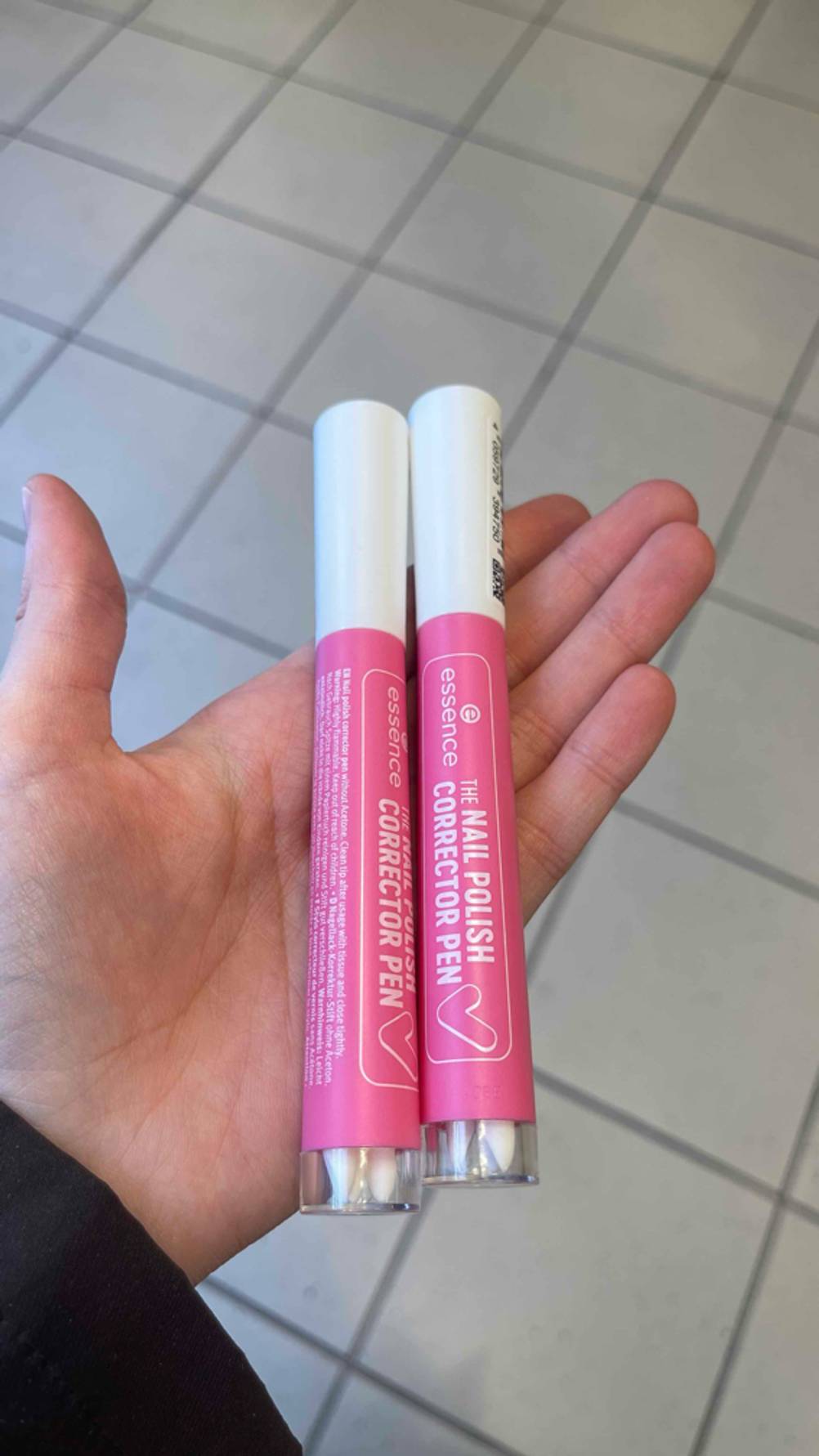Zwei getestete Nagellack-Korrekturstift liegen parallel nebeneinander in einer Handfläche.