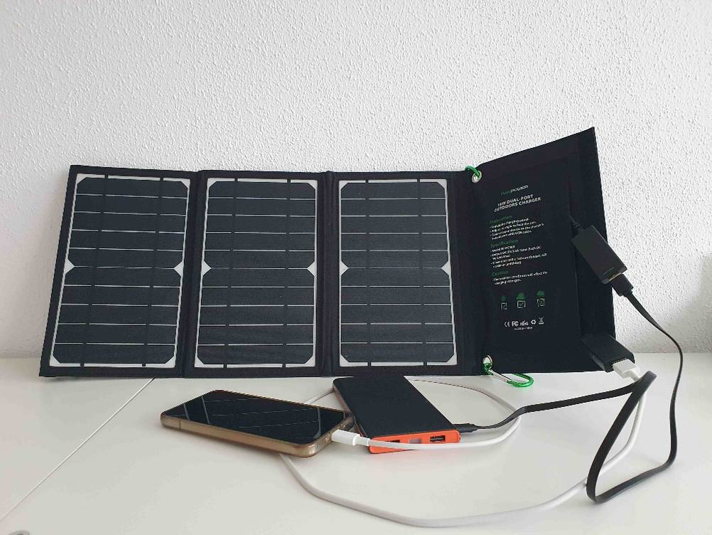 Die getestete mobile-Solaranlage ist an zwei Smartphones angesteckt.