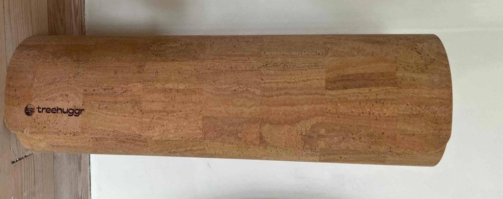 Im Test: Eine eingerollte Yogamatte aus Kork vor einer hellen Wand.