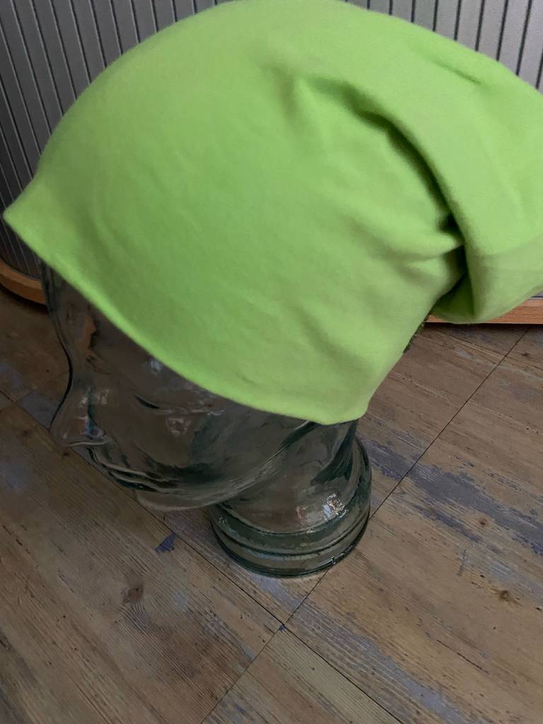 Beanie getestet: Seitenansicht von oben auf die grüne Mütze, die von einem Glaskopf getragen wird.