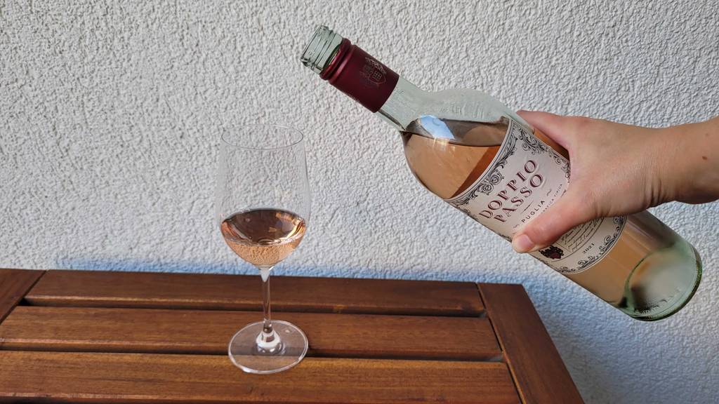 Roséwein wird in Glas eingefüllt.