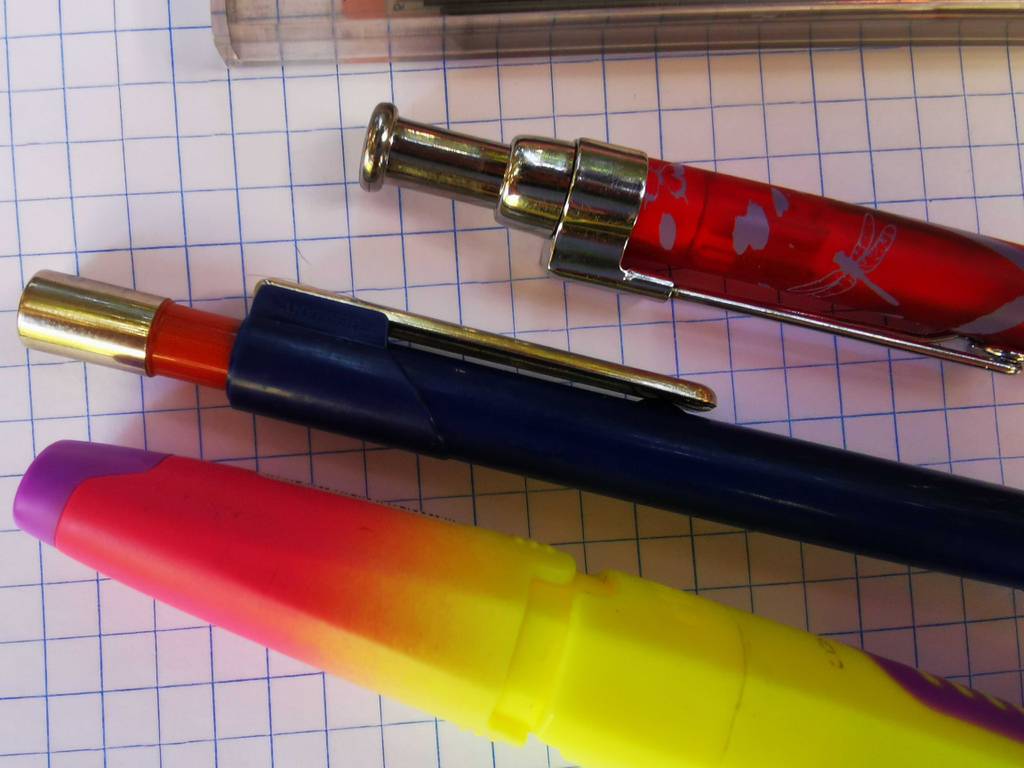 Drei verschieden farbige Druckbleistifte im Test liegen nebeneinander auf dem Rechnerpapier.