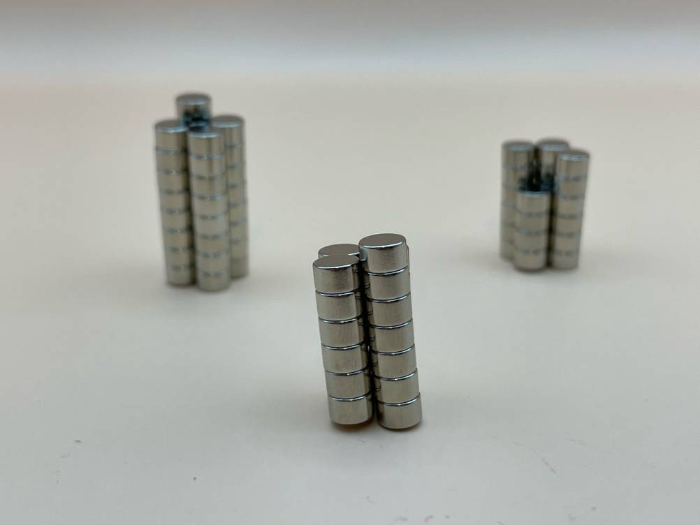 Mehrere Stapel der getesteten Kühlschrankmagnete befinden sich auf einer hellen Flläche.