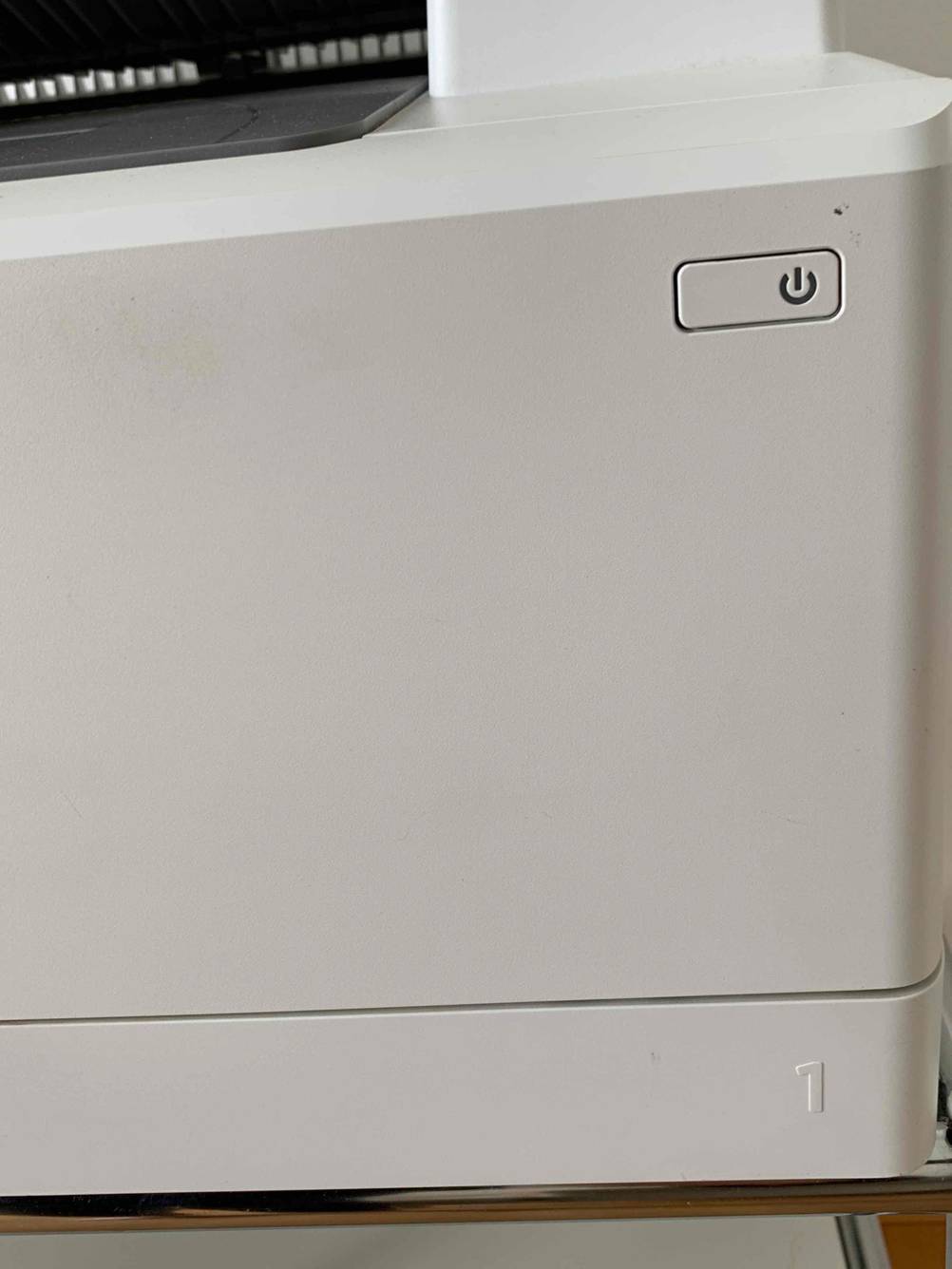 Im Test: Detailaufnahme Ein-Aus-Schalter eines Farblaserdruckers.