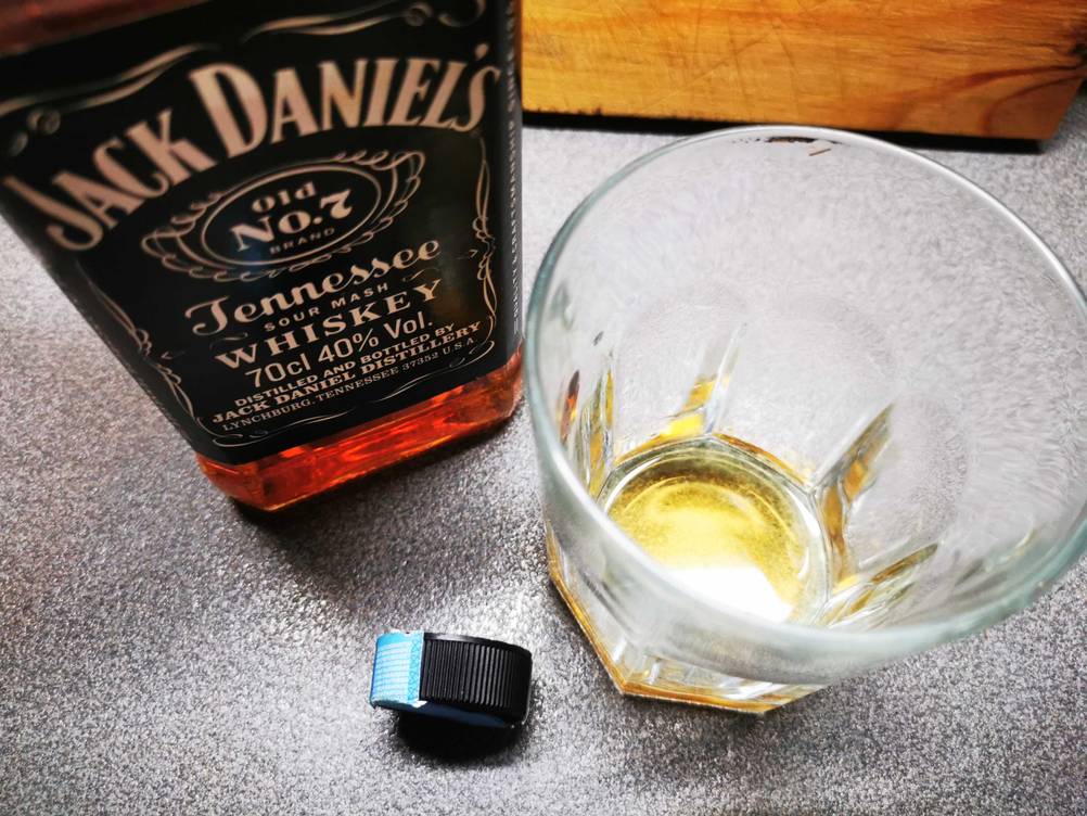 Die getestete Flasche Jack Daniel's steht neben einem Glas und dem Deckel.