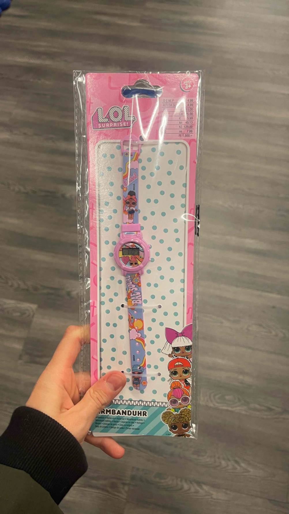 Die getestete Kinderuhr von LOL wird in der Hand gehalten.