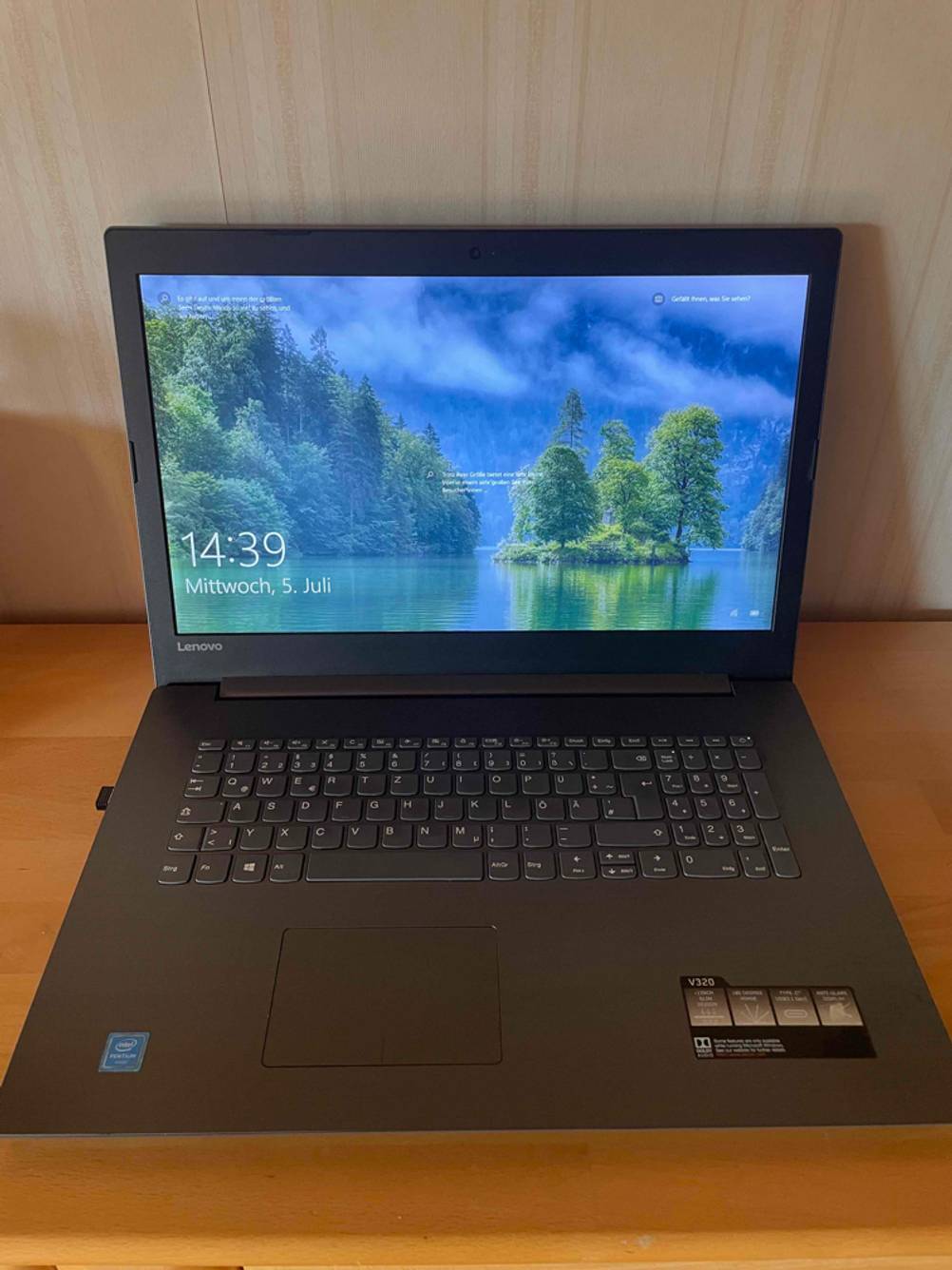 Im Test: Auf einer Holzoberfläche steht ein geöffneter Laptop mit DVD-Laufwerk.