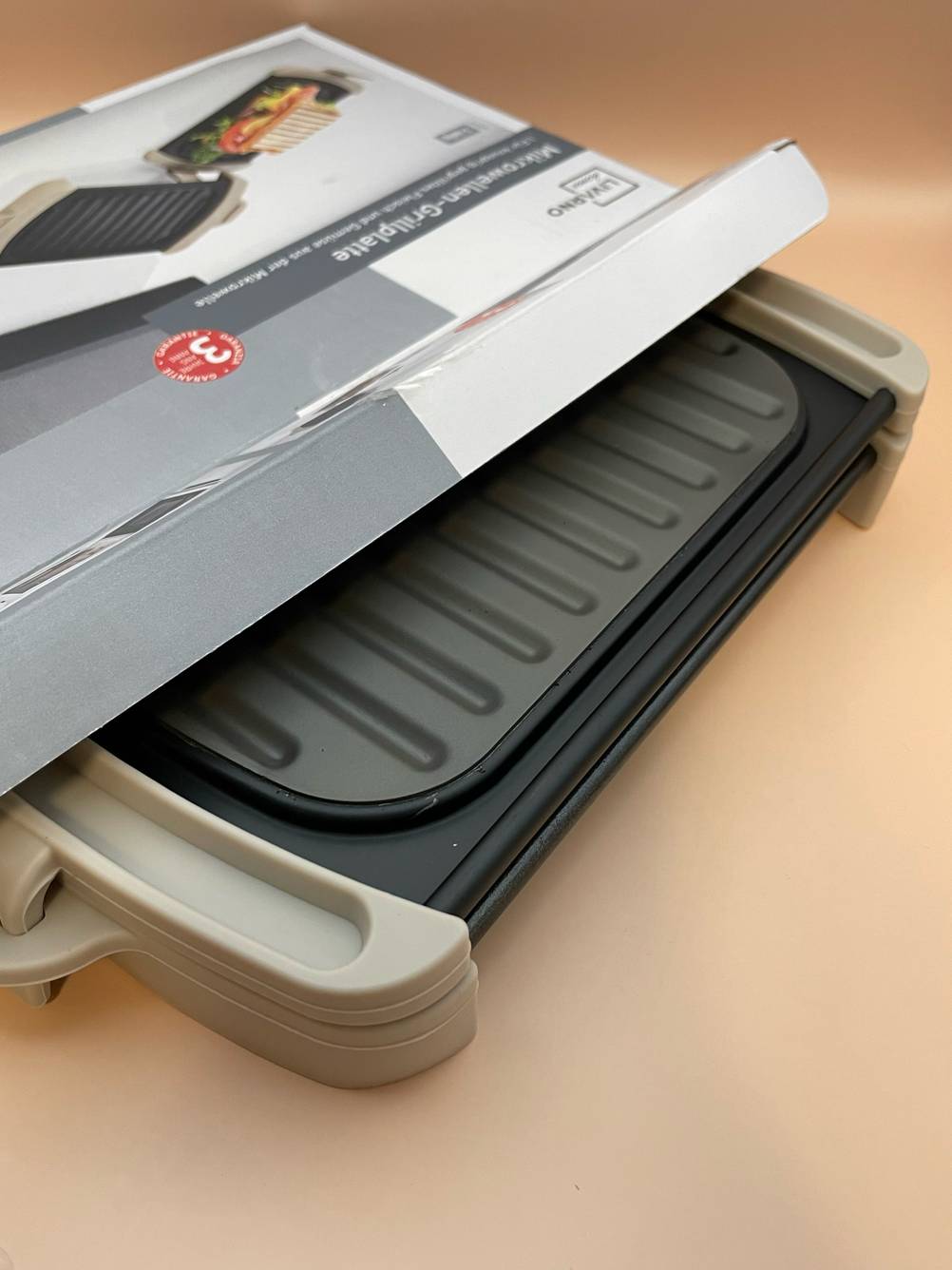 Die Grillplatte, die getestet wurde ragt aus der Verpackung heraus.