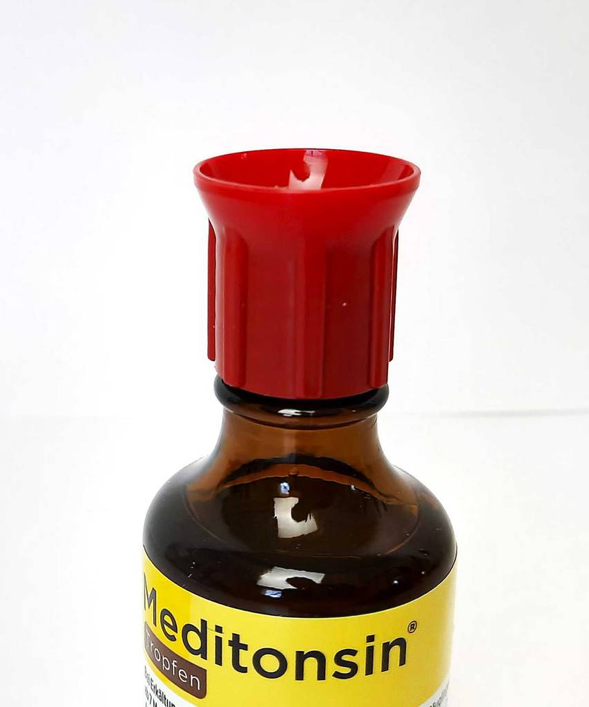 Getestete Hunstentropfen in der Flasche mit rotem Verschluss stehen vor einer weißen Fläche.
