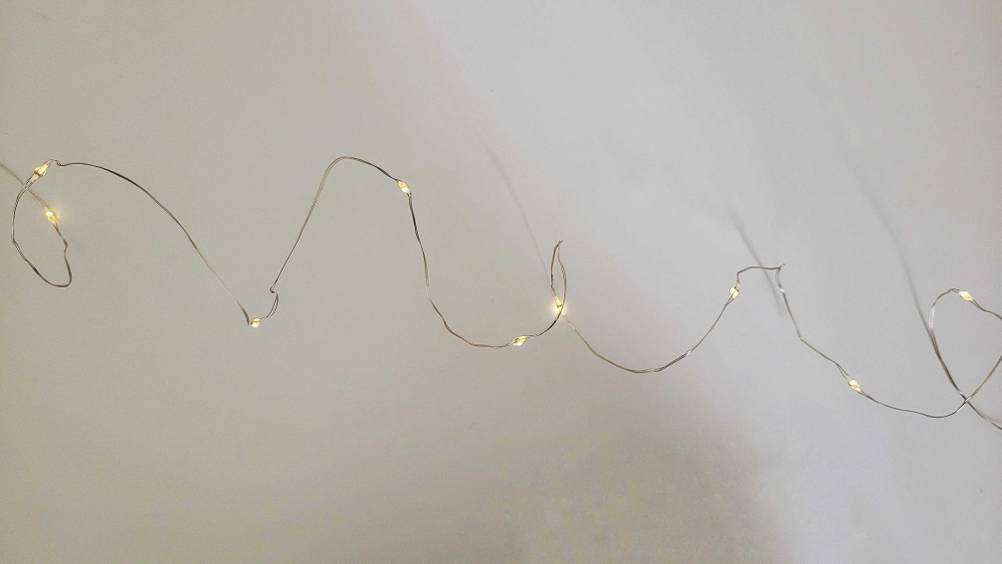 Lichterkette-Test: Eine filigrane Lichterkette aus Draht vor einem hellen Hintergrund.