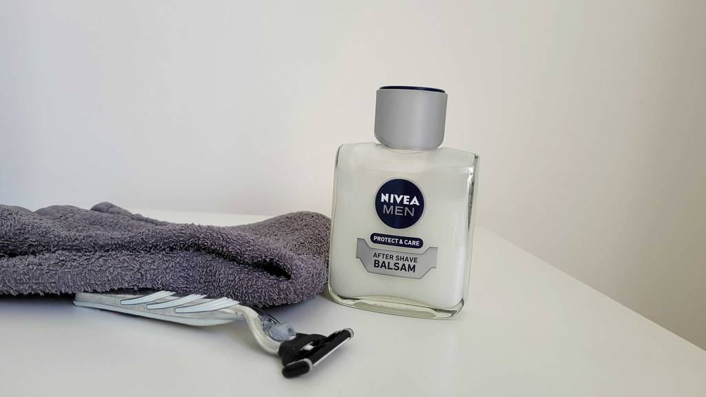 After-Shave-Balsam getestet: Nivea After-Shave, Rasierer und Handtuch auf einem weißen Tisch.