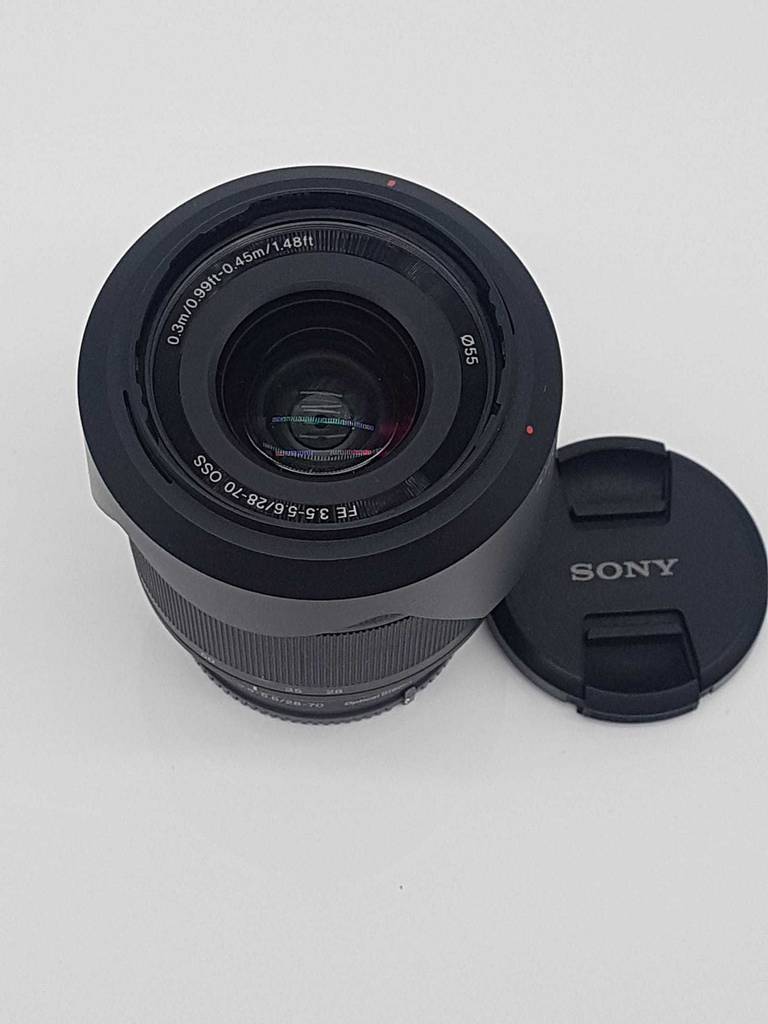 Geöffnetes, getestetes Sony-E-Mount-Objektiv mit Schutzabdeckung daneben liegend.