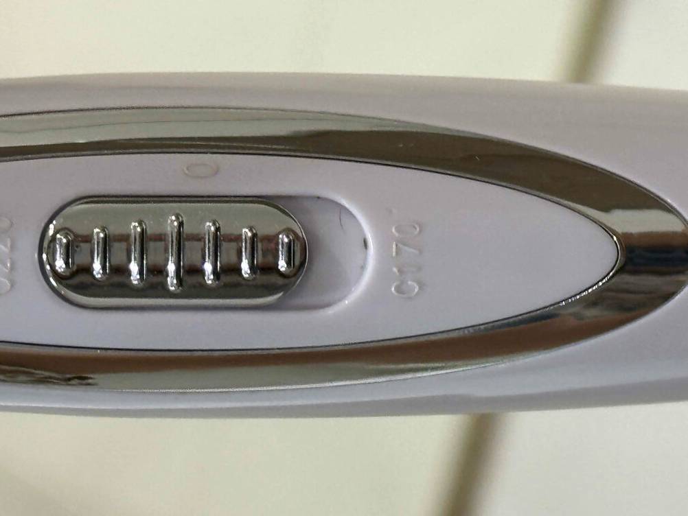 Bedienelement eines getesteten Lockenstabs mit 3 Stäben