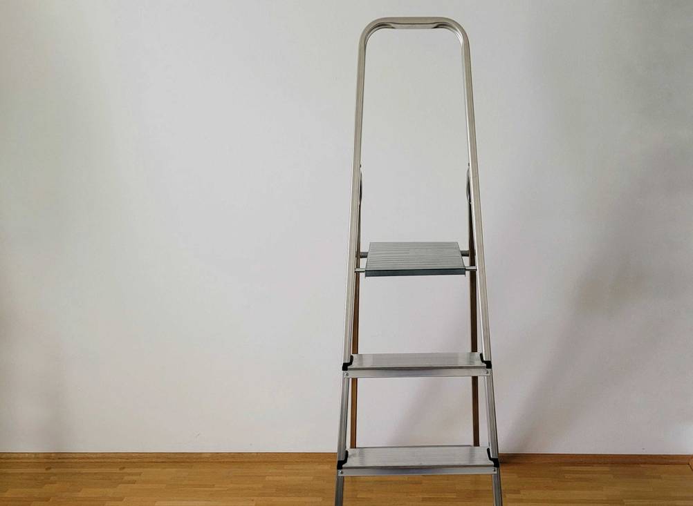 Aluleiter-Test: eine aufgestellte Aluleiter vor einer weißen Wand stehend.