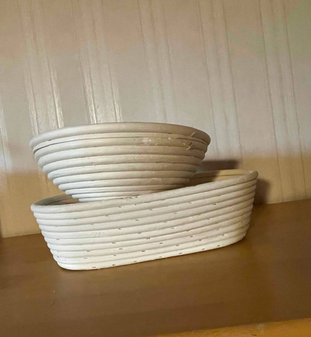 Gärkörbchen getestet: Zwei Körbchen, eines rund, eines oval übereinander vor einer hellen Wand.
