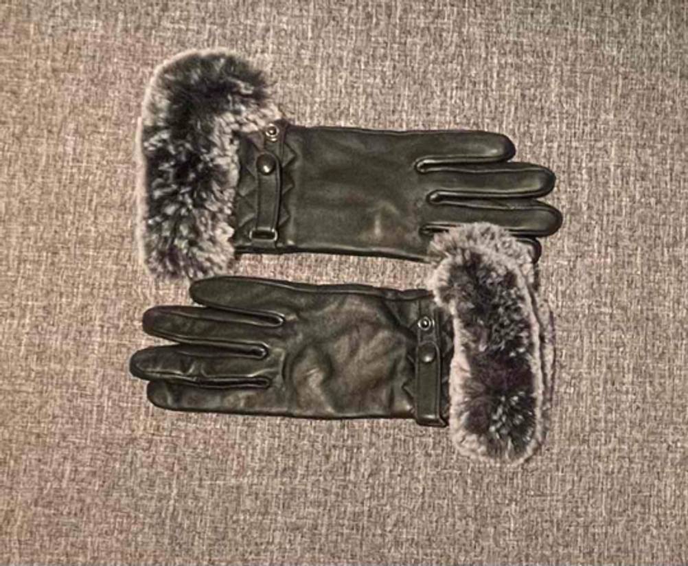 Lederhandschuhe Damen im Test: Zwei Handschuhe nebeneinander auf einer grauen Stoffoberfläche