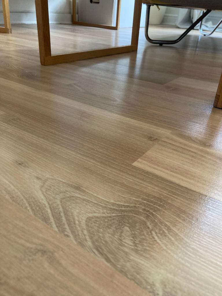 Parkett im Test: ein Parkettboden in einem Wohnraum ausgelegt worauf Möbel stehen.