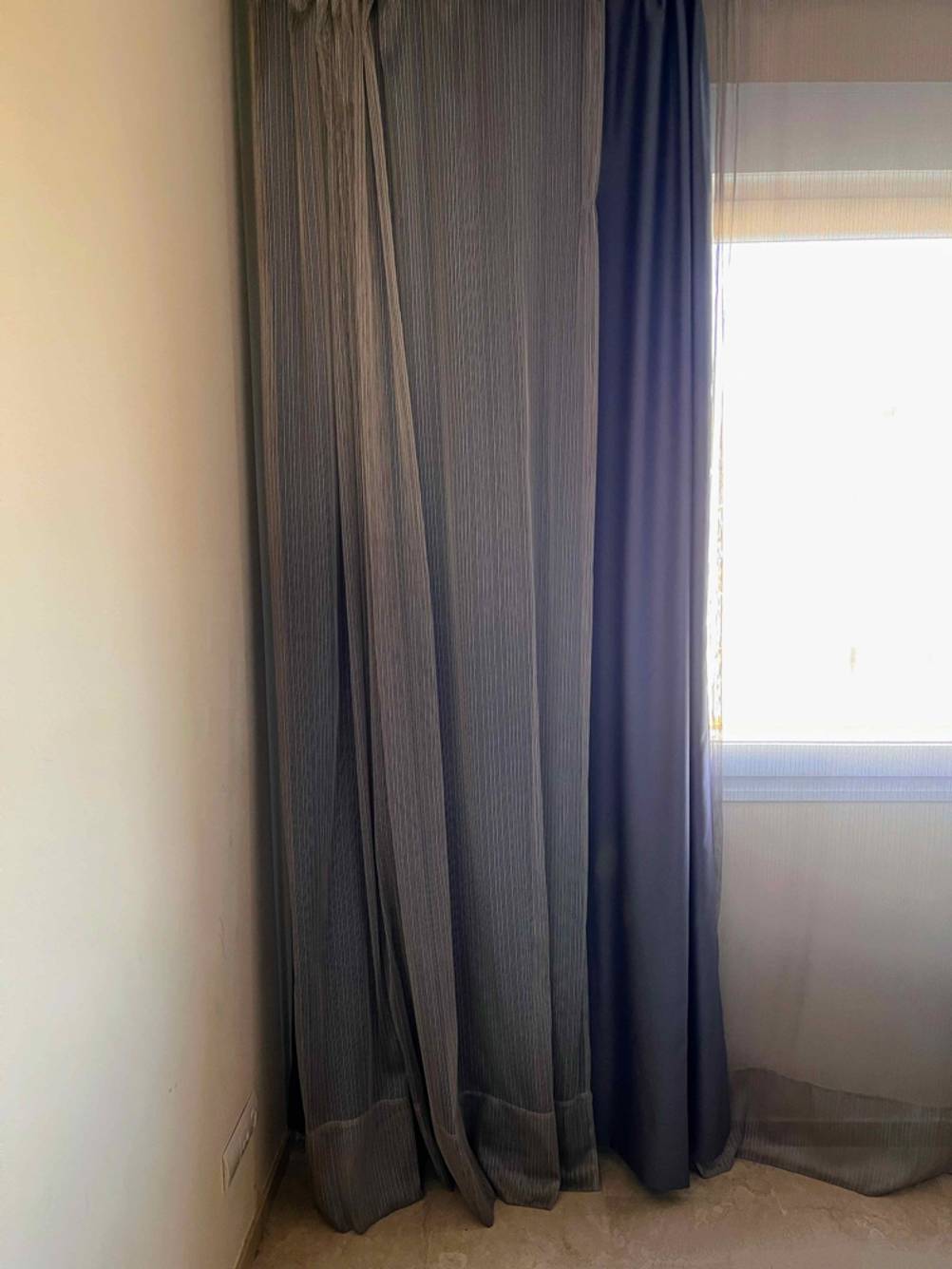 Die getesteten blickdichten Vorhänge hängen an einem Fenster auf der linken Seite