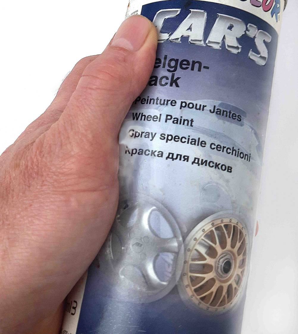Der getestete Felgenlack in der Farbe Silber wird in der Hand gehalten.