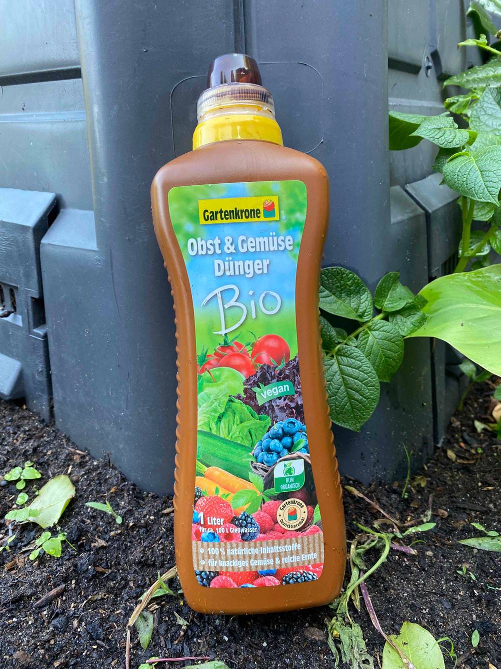 Im Test: Eine Flasche Gemüsedünger lehnt an einem Hochbeet.