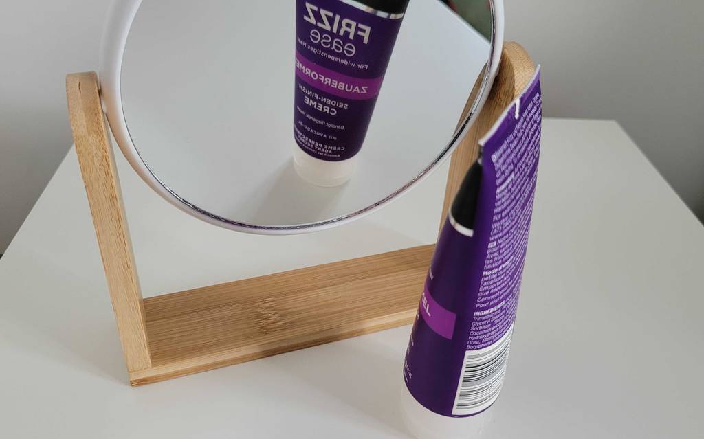 John Frieda Frizz Ease Haarcreme vor einem Spiegel