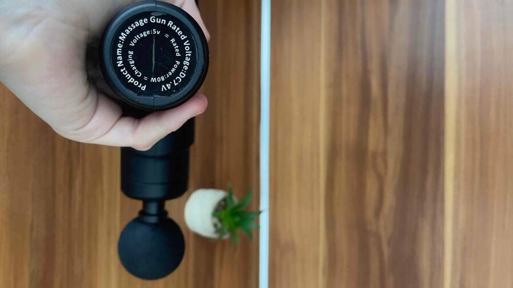 Nahaufnahme der Voltangabe auf der batteriebetriebenen Mini-Massagepistole im Test.