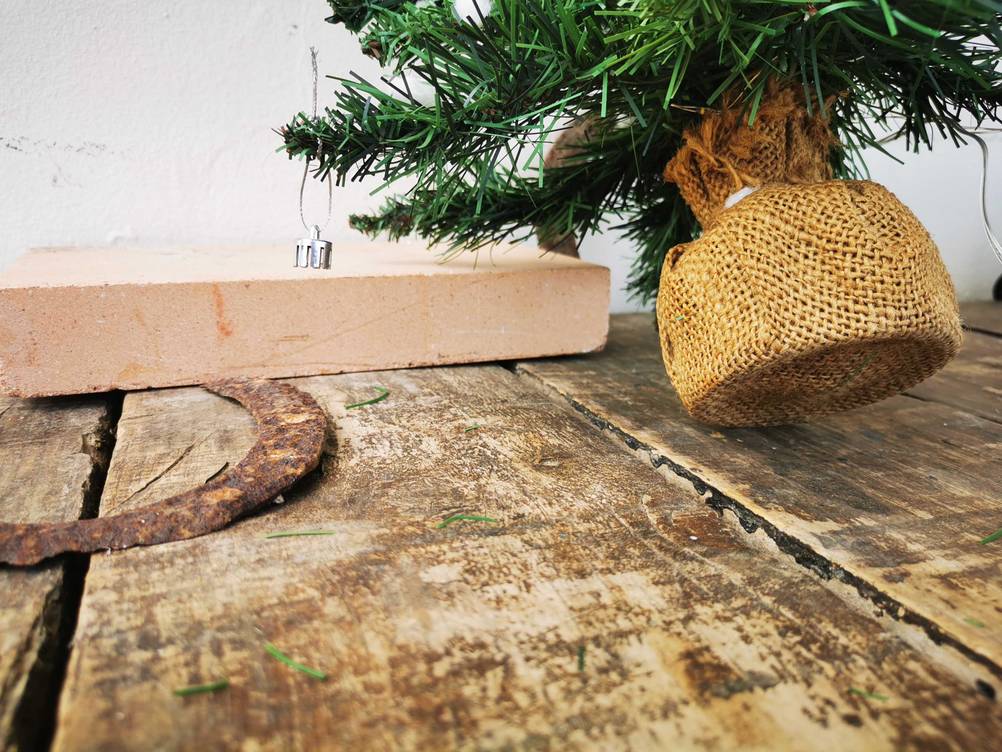 Der untere Teil des getesteten Mini-Weihnachtsbaums im Fokus, während er an eine Wand gelehnt ist.
